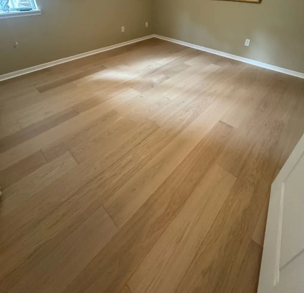 Wide-plank wood flooring installed in an empty room by Advanced Flooring Removal